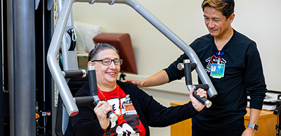PT working with participant on weight machine